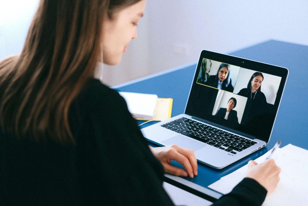 Three people connecting online during a virtual networking session, building relationships in the social impact space.