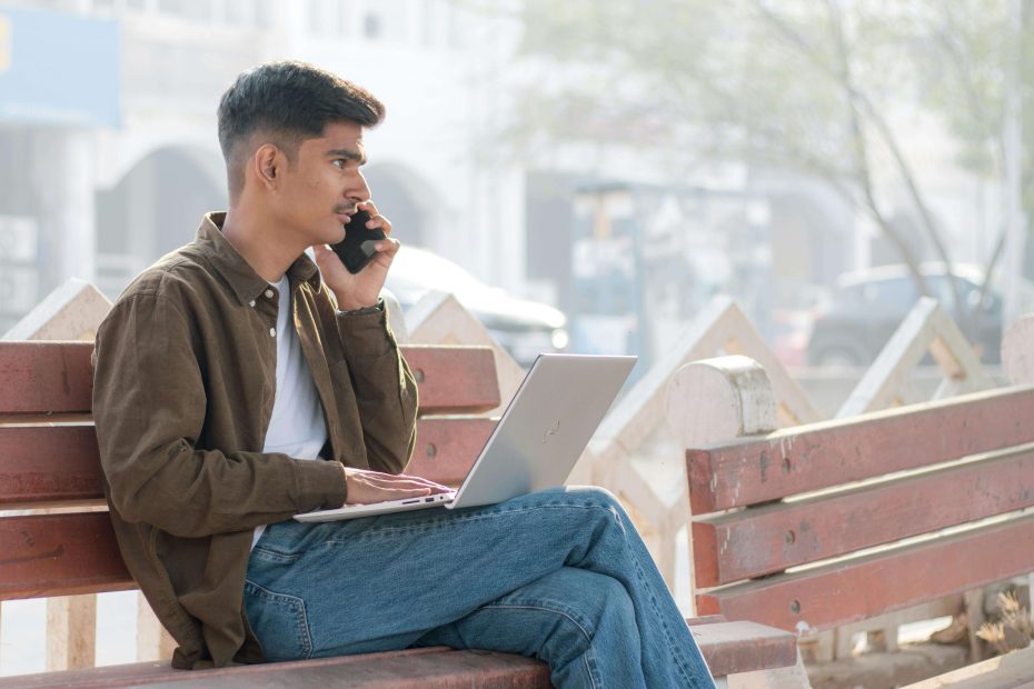 Man working remotely outdoors on a laptop, enjoying a flexible career.